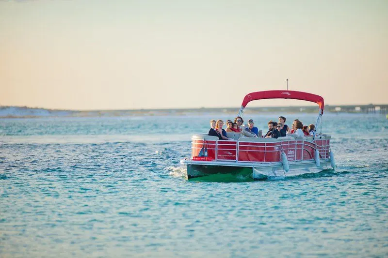 A large family aboard Luther's red 28ft pontoon boat at sunset