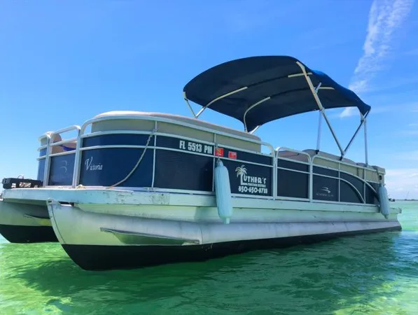 The 24ft pontoon boat “Victoria” cruising turquoise water under a bimini top