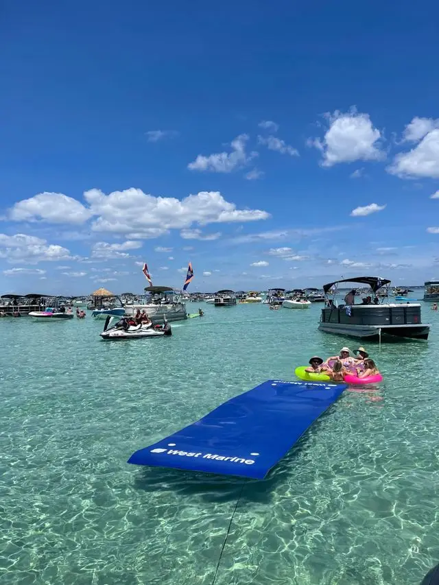 A wide view of boats anchored at Crab Island with guests enjoying the water